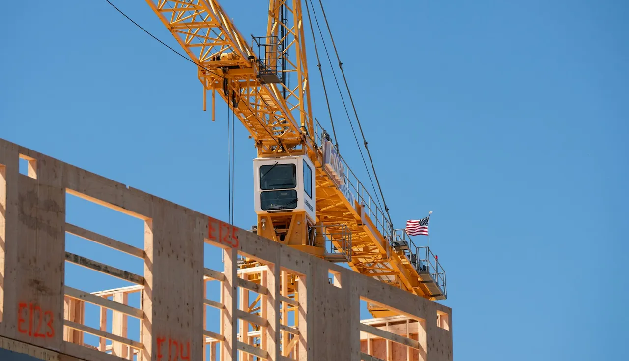 Guindaste sobre um prédio em construção, com a estrutura de concreto ainda exposta