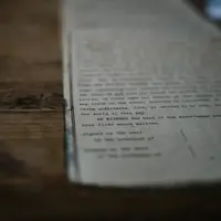 Documento impresso com texto miúdo sobre uma mesa de madeira