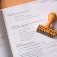 Carimbo de madeira apoiado sobre papéis impressos