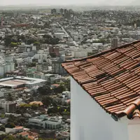 Telhado de cerâmica em primeiro plano sobre um bairro urbano brasileiro visto de cima