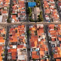 Vista aérea de um bairro residencial brasileiro, com quadras de casas de telhado de cerâmica cortadas por ruas retas