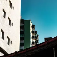 Conjunto de prédios residenciais altos em uma cidade brasileira, vistos da rua sob céu azul.