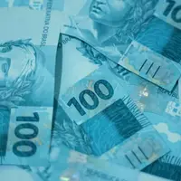 Notas de cem reais espalhadas sobre uma superfície